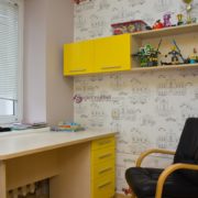 Письменный стол в детской комнате с навесной полкой для книг
